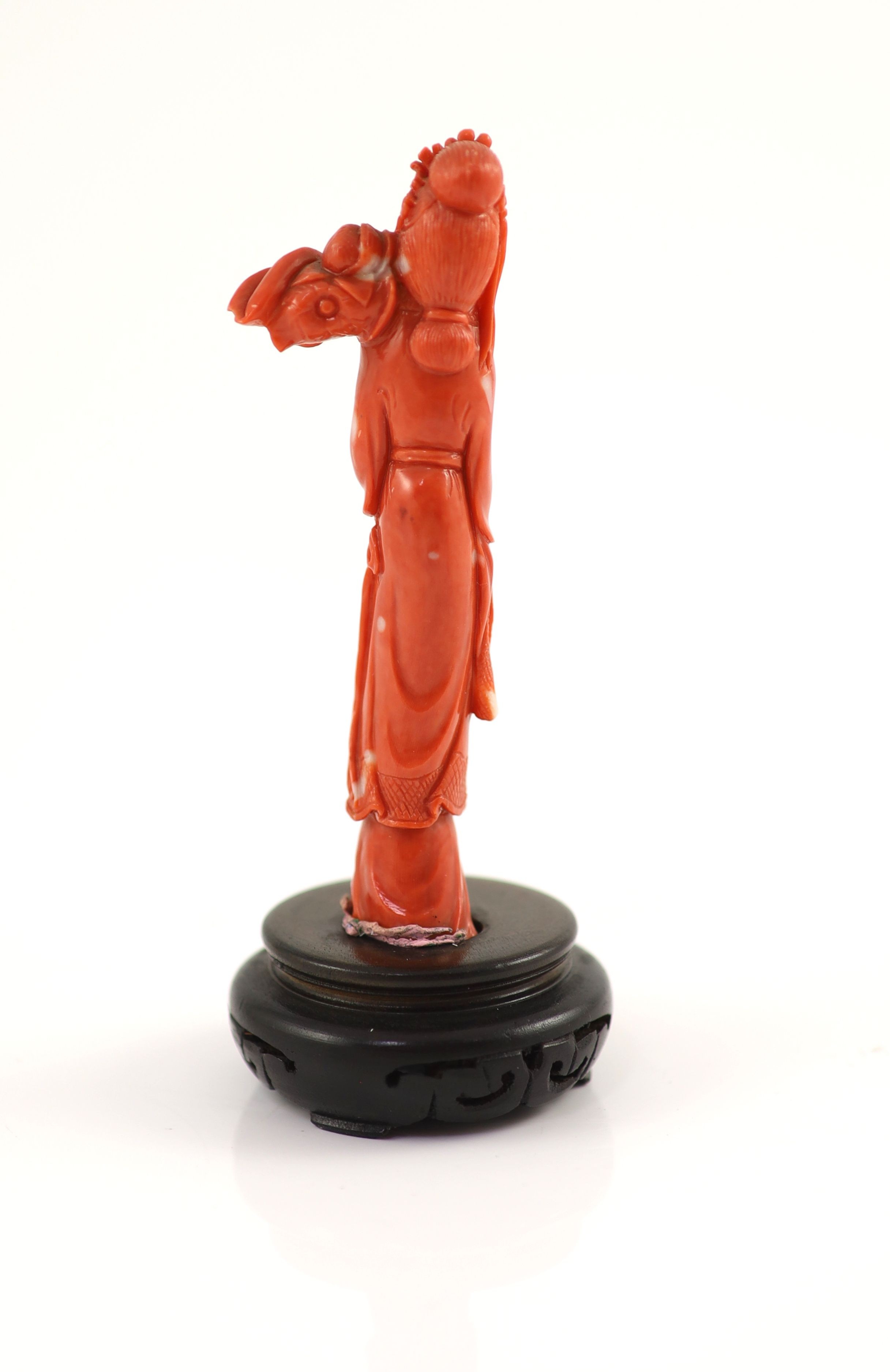 A Chinese coral figure of a tall lady holding a Lotus sprig, mid 20th century 11.1 cm high, 59g, wood stand